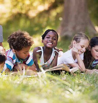 Kids reading outdoors in Central Park, Manhattan, New York.