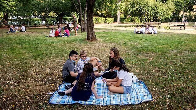 Children sitting on a blanket in Central Park, New York City.