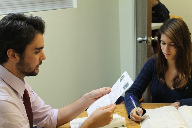 Tutor and student studying at table